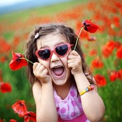 Cute child girl in poppy field